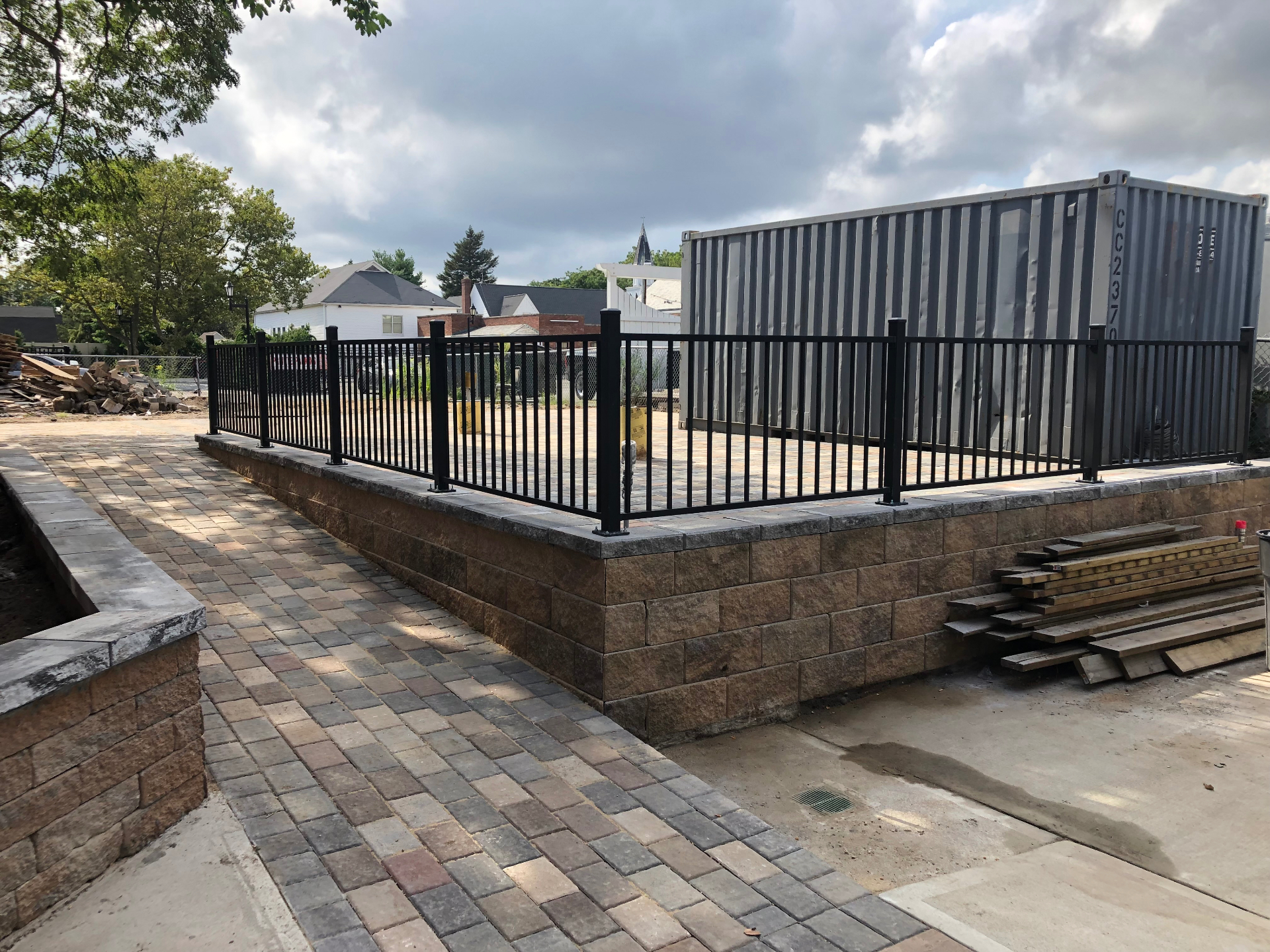 Finished raised paver patio with retaining wall and railing
