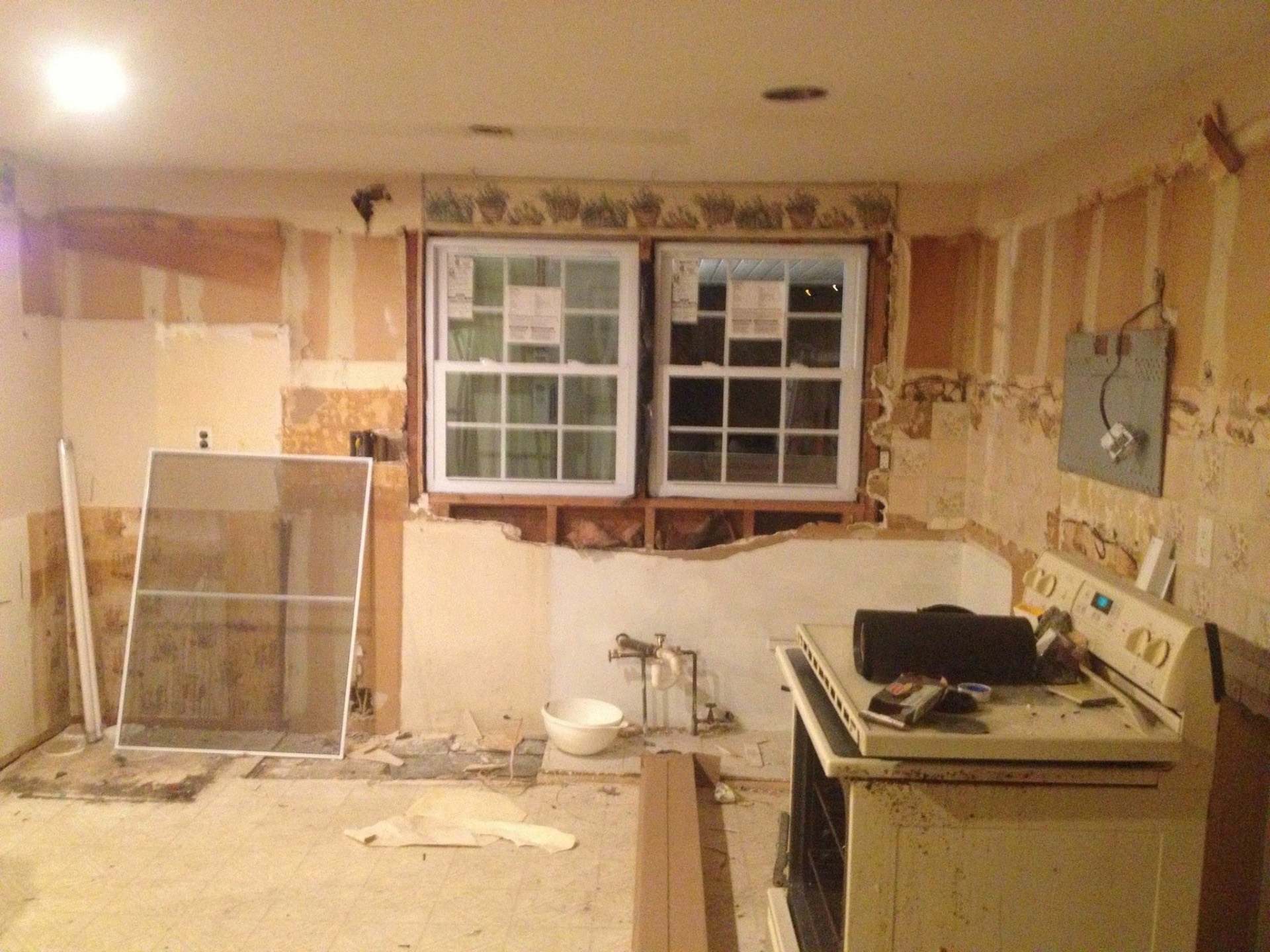 Gutted kitchen with stripped walls before renovation